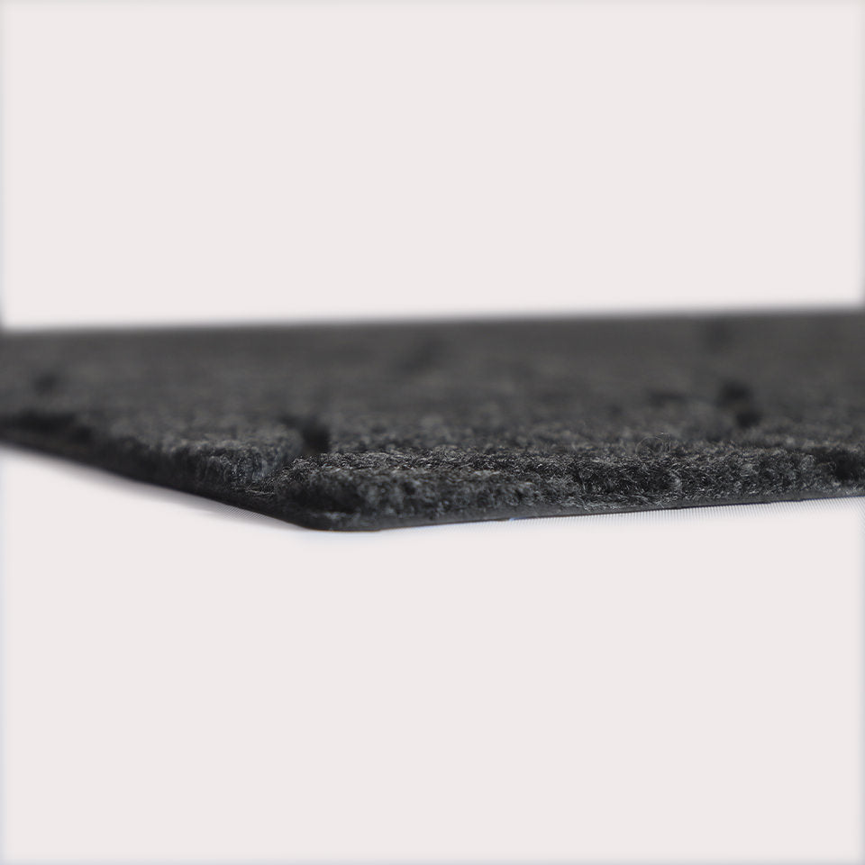 Profile corner image of the Magnolia doormat in graphite, showing the overall 3/8” height and rubber backing.