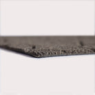 Profile corner image of the Magnolia doormat in greige, showing the overall 3/8” height and rubber backing.