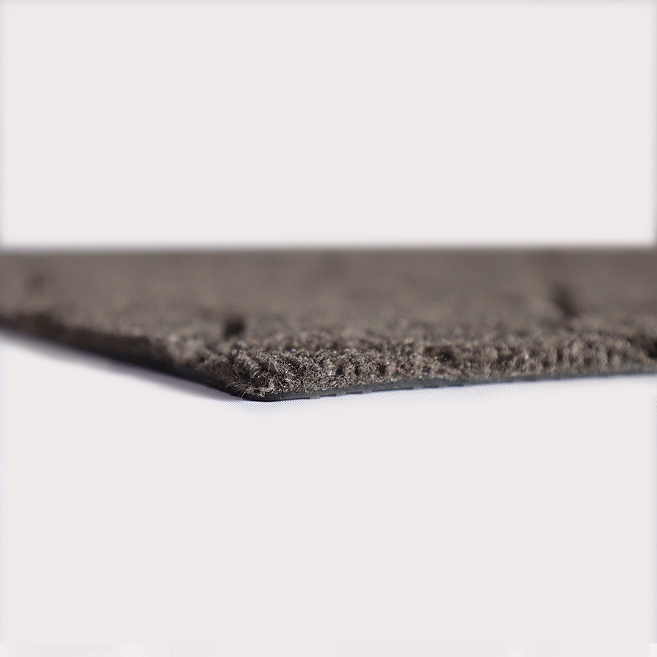 Profile corner image of the Magnolia doormat in greige, showing the overall 3/8” height and rubber backing.