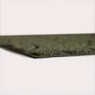 Profile corner image of the Magnolia doormat in olive, showing the overall 3/8” height and rubber backing.