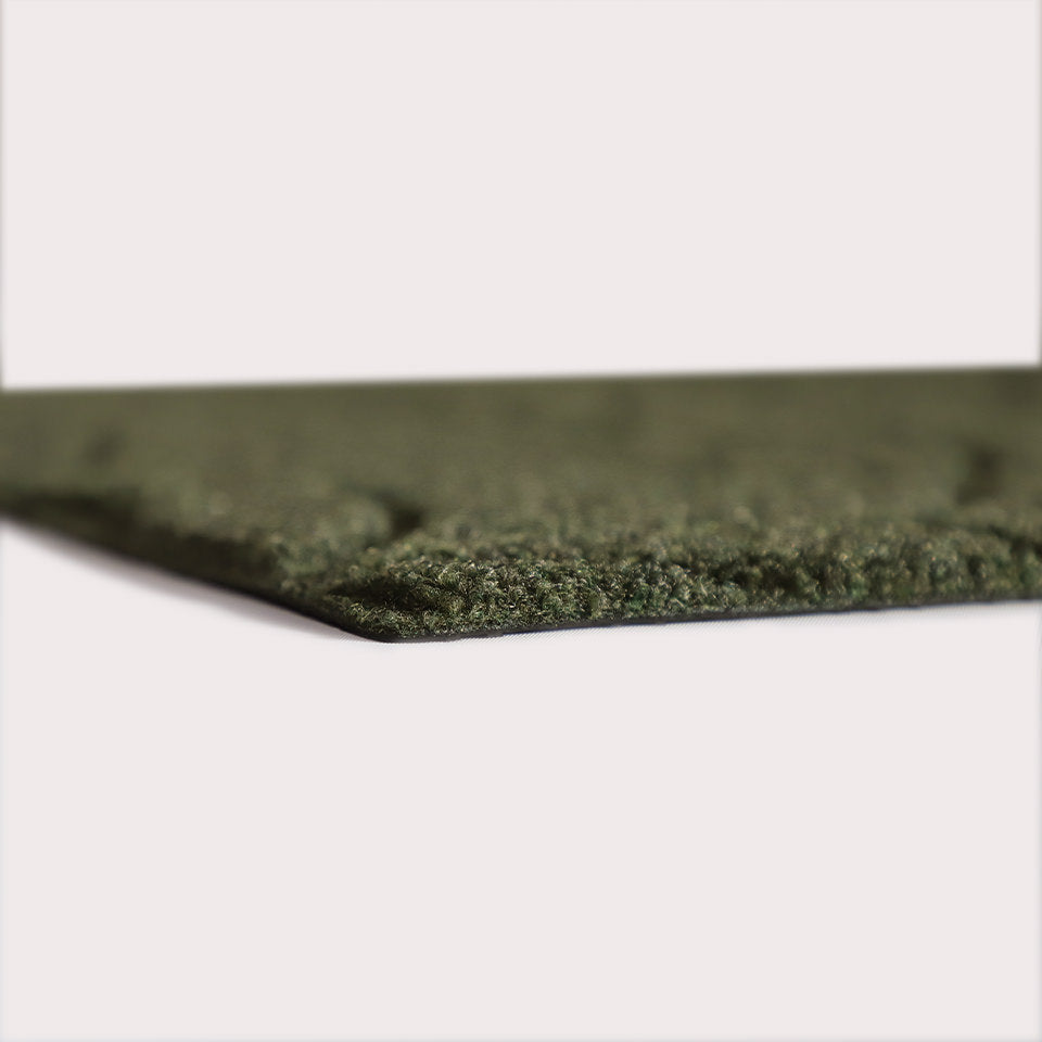 Profile corner image of the Magnolia doormat in olive, showing the overall 3/8” height and rubber backing.