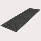 Angled image of the double-door Magnolia mat in the color graphite on a creamy white background.