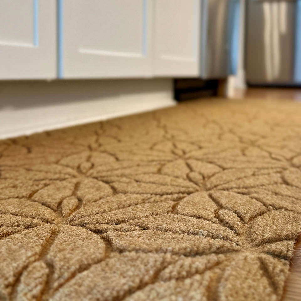 Low-profile WaterHog Luxe all-weather kitchen mat double door along a kitchen island.