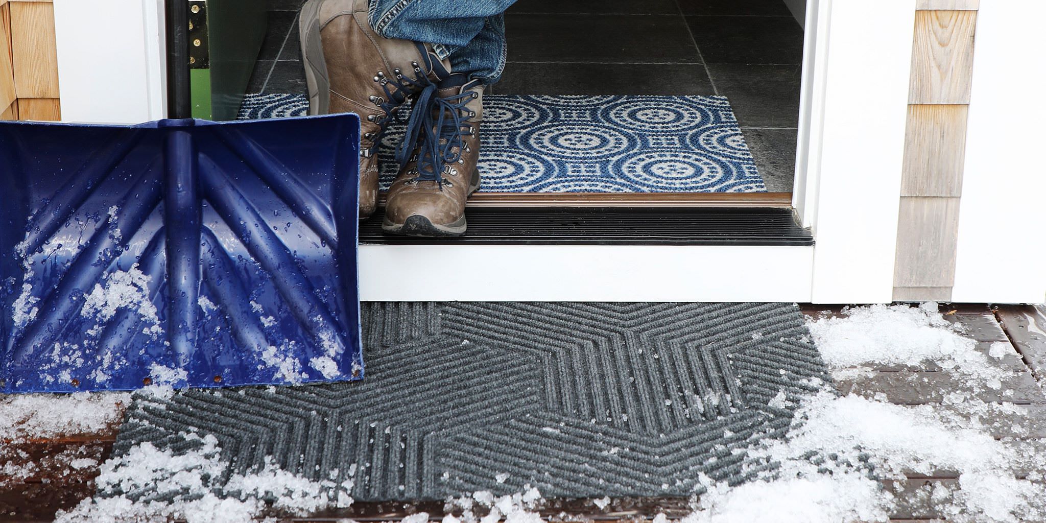 Durable and long lasting all-weather doormat placed at front door with winter snow. These long lasting doormats are great at scraping snow, ice, dirt, rain, and mud from the bottom of shoes and boots.
