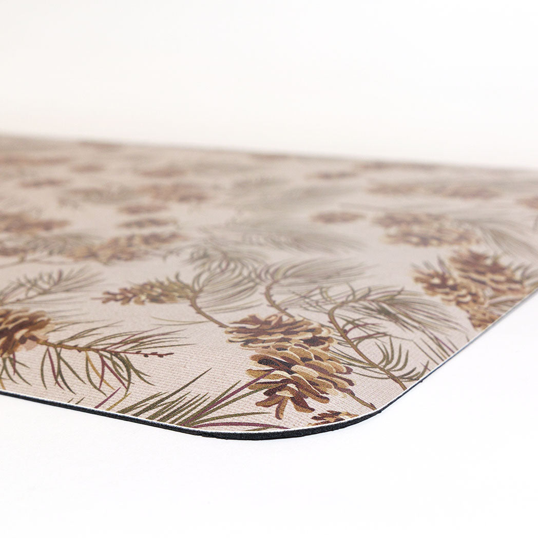 Detail corner of pinecone fall anti-fatigue kitchen mat with wipeable surface and festive holiday design for kitchen comfort