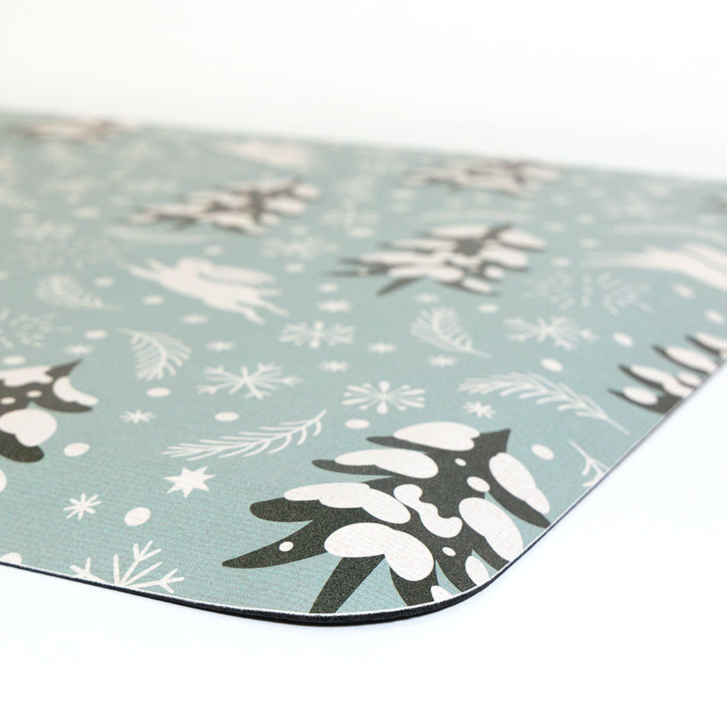 Corner detail of snow bunny fall anti-fatigue kitchen mat with wipeable surface and winter holiday design for kitchen comfort.