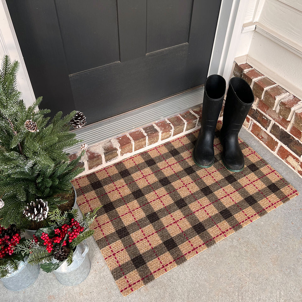 Tattersall Plaid single door doormat with a pair of boots and small decorative winter tree.
