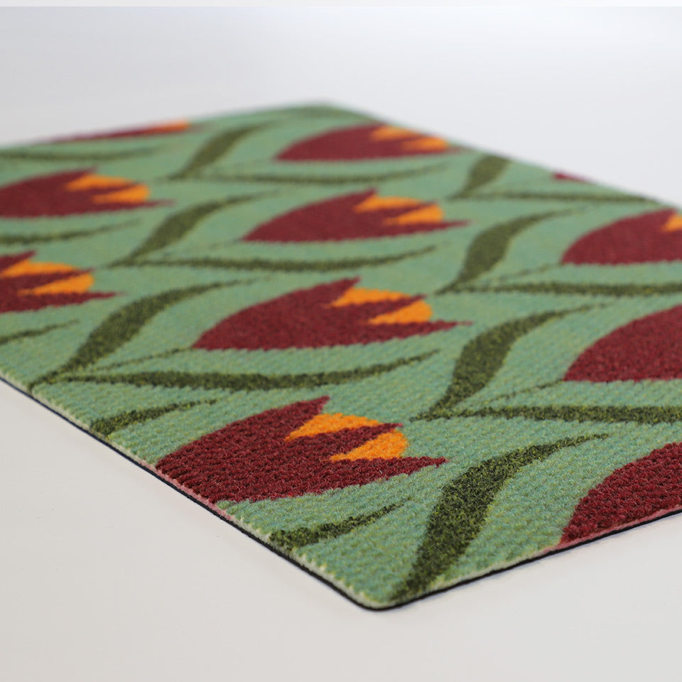 light green and berry buttercups doormat laying flat on white surface