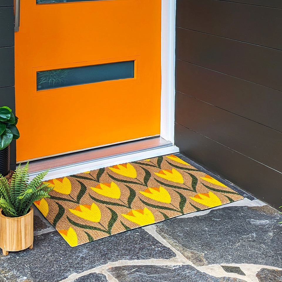 single sized coir and yellow buttercups doormat in front of orange front door