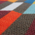 closeup of fabric surface showing colors grey, red, blue, white, and berry
