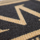 Black and brown letter doormat; the Escher doormat features elegant single text in the center of your doormat and is printed on a durable recycled fiber surface in brown and black.