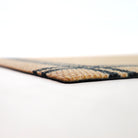 Side view of low profile doormat in tan and black