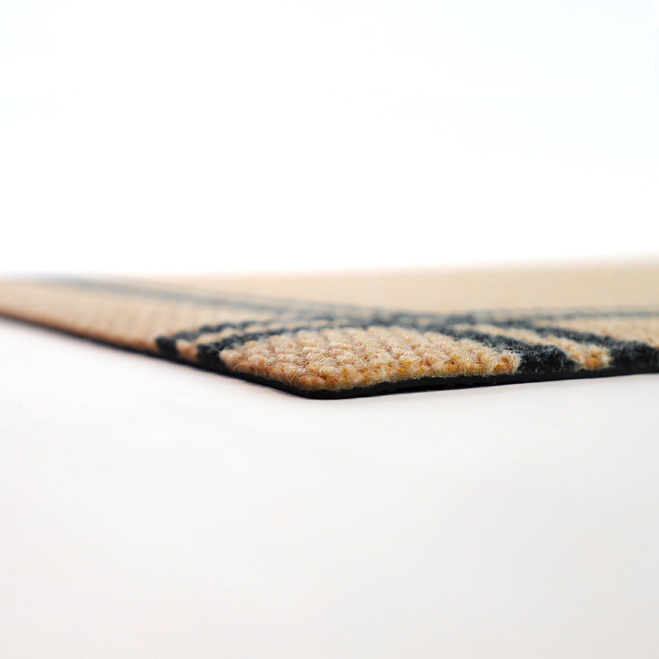 Side view of low profile doormat in tan and black
