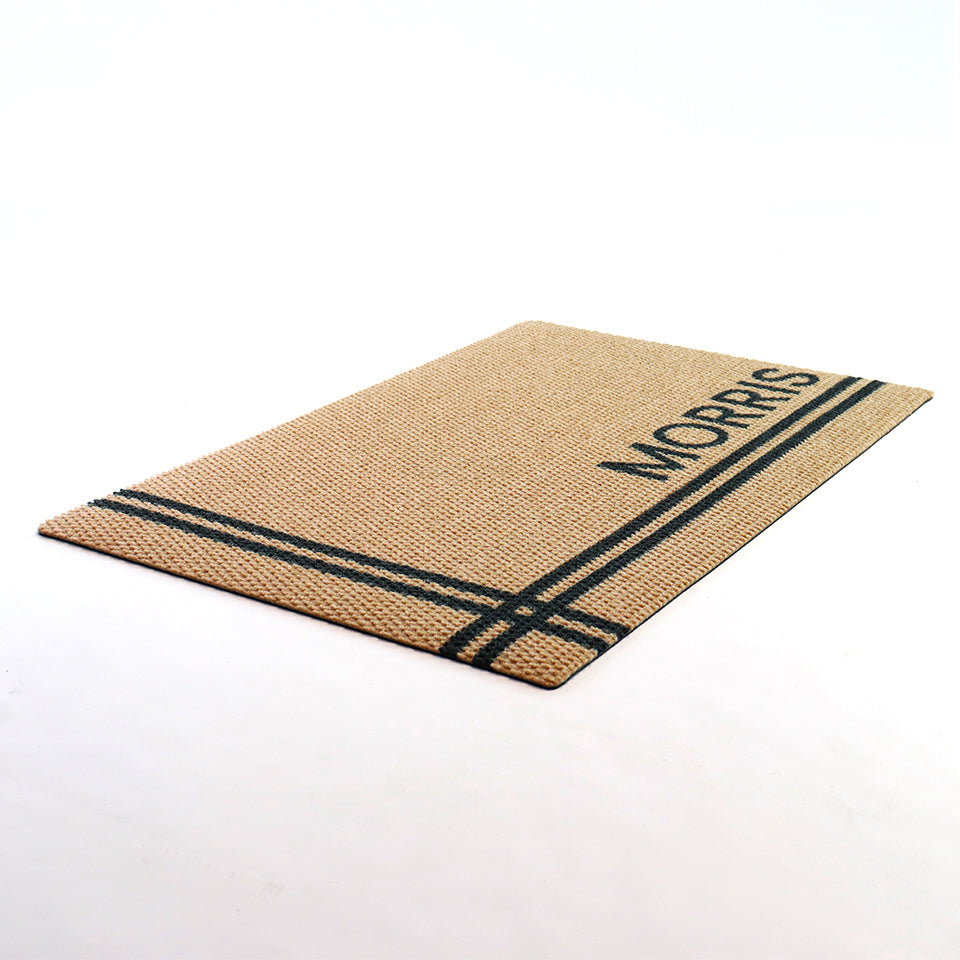 Angle shot of personalized doormat in tan with black lines customized with last name