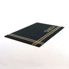 Angle shot of black and tan personalized doormat customized with last name