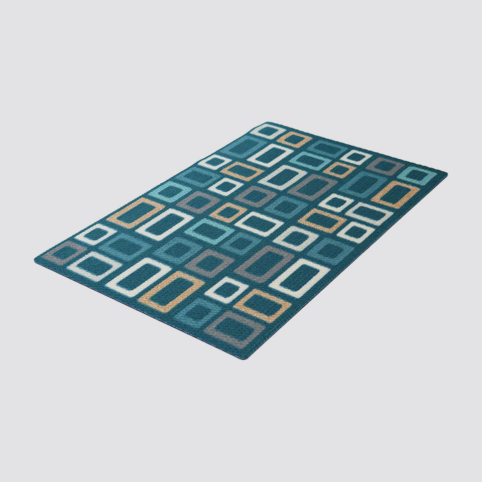 Angle shot of aqua doormat with mid century modern inspired squares on an aqua background