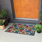 Multi colored retro squares on a dark brown doormat in front of a covered front porch