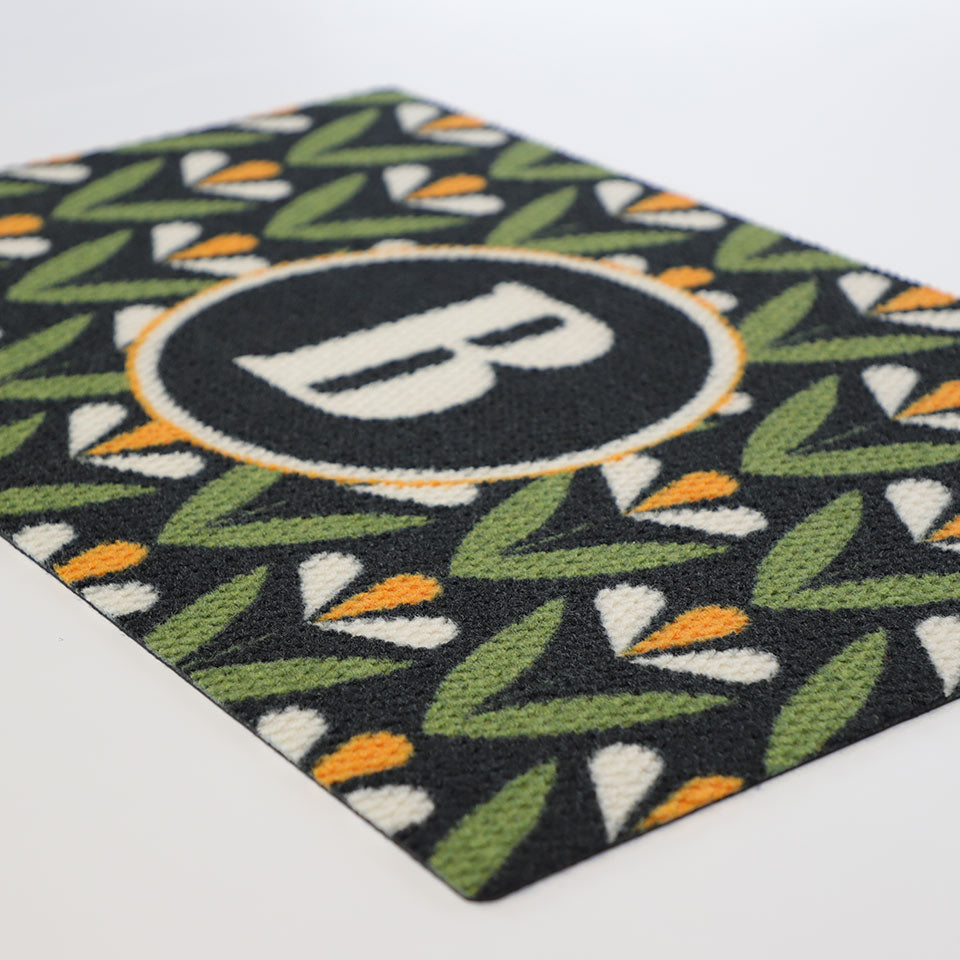 Angled shot of Spring Blooms monogrammed doormat - personalized with your initial for a customized front porch or entryway. Part of our Mid Century Modern collection of doormats.