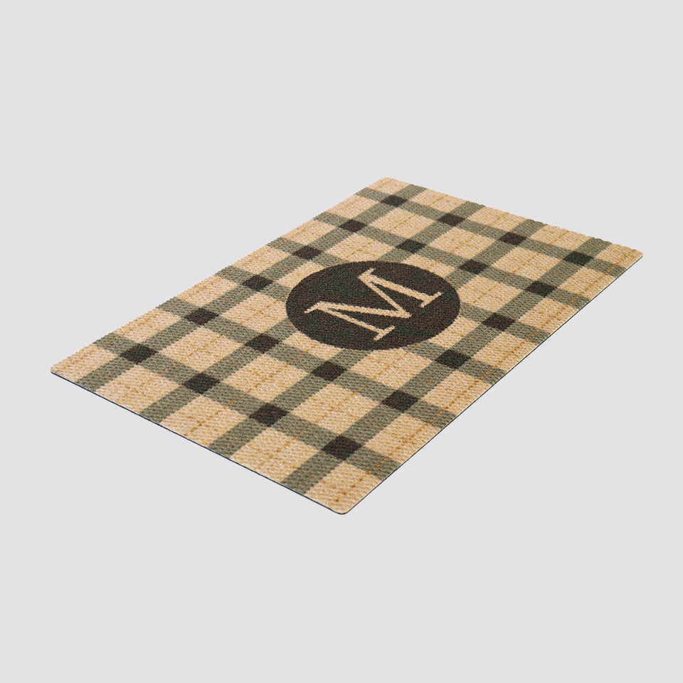 Angle shot of coir and black plaid monogrammed doormat personalized with your initial.