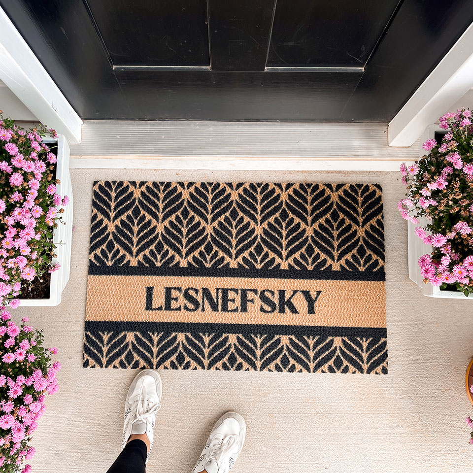 botanical personalized mat with last name in front of front door