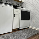 double door size escher doormat in black and white in front of washer and dryer in laundry room