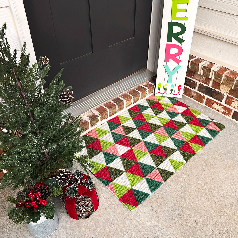 Modern triangle Christmas doormat with green red pink white and lime green triangle accents
