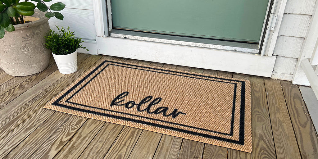 Neighburly Around the Block personalized doormat featuring a family last name in a black and brown color scheme and is placed at a green front door in order clean the bottom of shoes and boots before they go indoors.