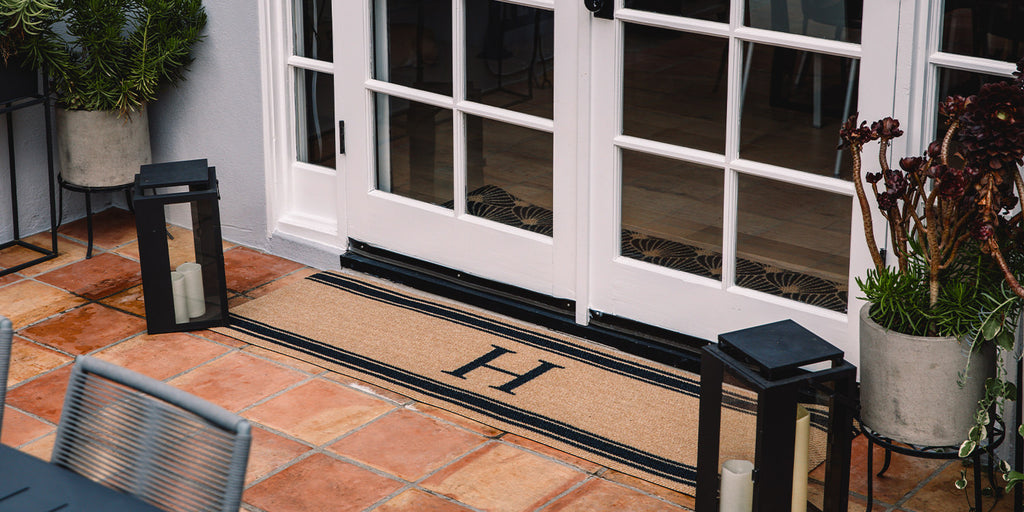 Double door Neighburly mat personalized with your middle initial in the center of a non-shedding surface.