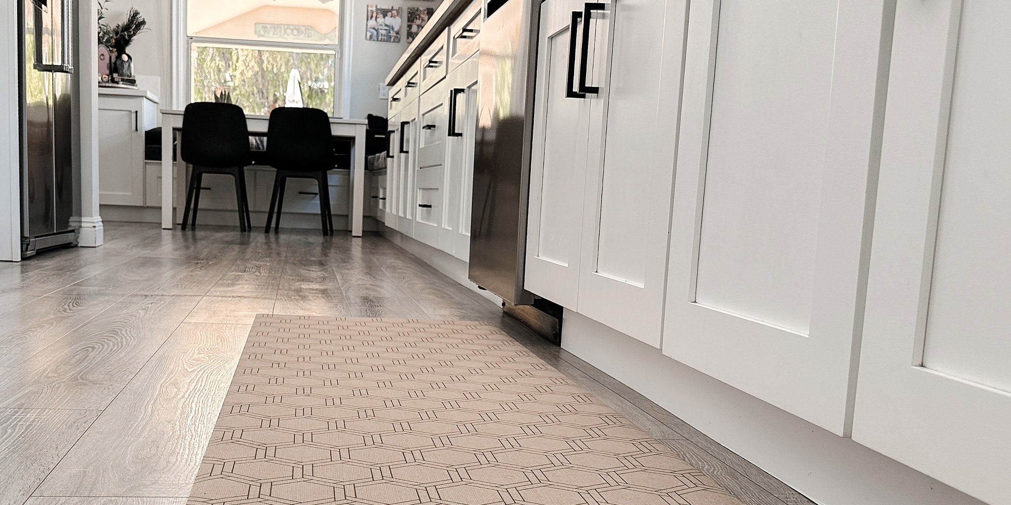 Low-Profile Un-Rug kitchen runner mat in honeycomb pattern placed in front of a dishwasher.