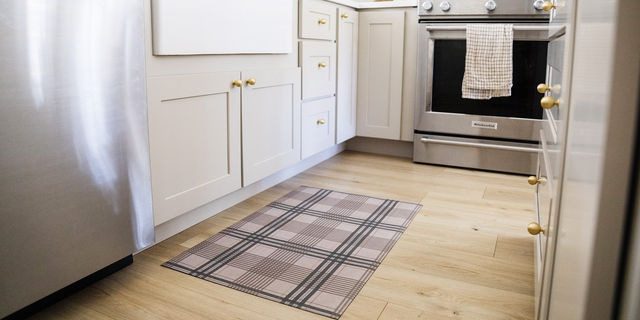 Un-Rug kitchen mat in a traditional plaid pattern is placed at the base of a farmhouse style kitchen sink.