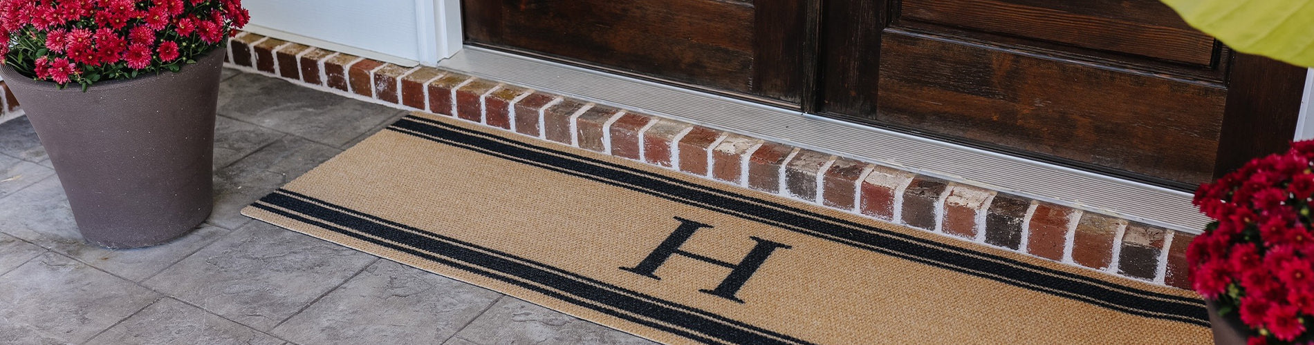 Matterly monogrammed doormat in a double door size placed at a covered front door.