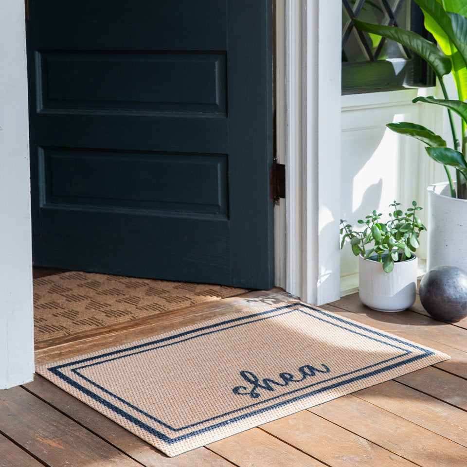 Nieghburly's Around The Block low-profile single door mat personalized with the last name Shea at the entrance of a home.