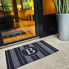 Chic and modern doormat, the Neighburly Basic Stripe Monogrammed doormat enhances the look of a glass front door entryway.