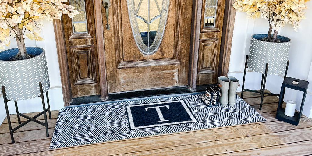 Escher Monogrammed double door mat is a large and wide doormat placed in front of a nice wooden front door with sidelights.