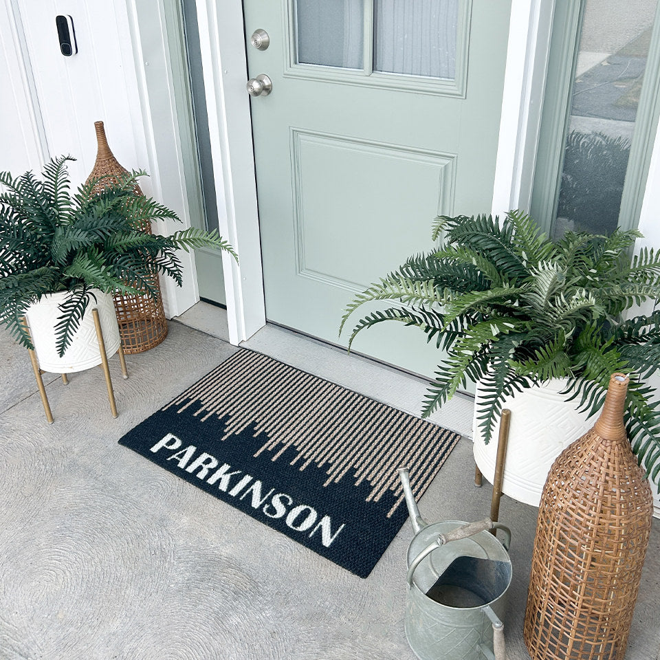 Neighburly's Fall In Line non-shedding mat personalized with the last name Parkinson in front of a sage green door.