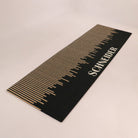 Angled shot of Fall in Line personalized double-sized doormat featuring a last name in white on a black and coir design.