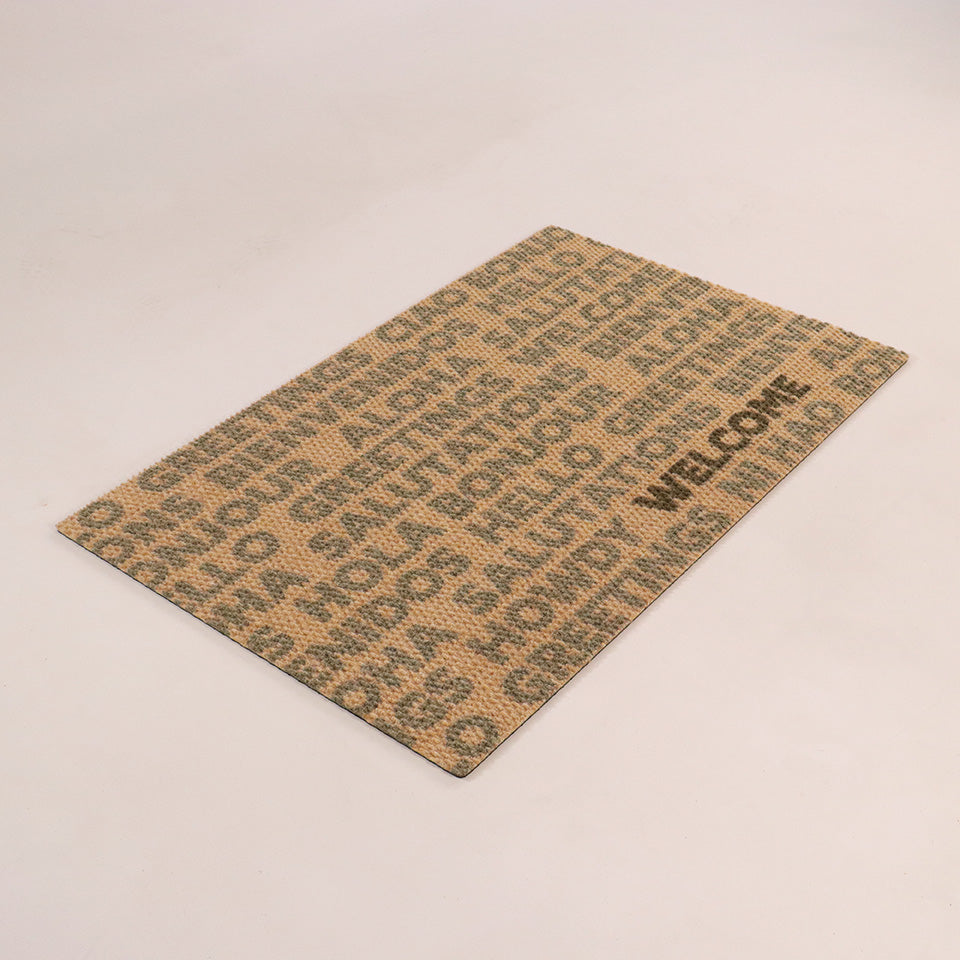 Single door angled Global Greetings mat army colored text on coir repeating bilingual greetings with one black hello text