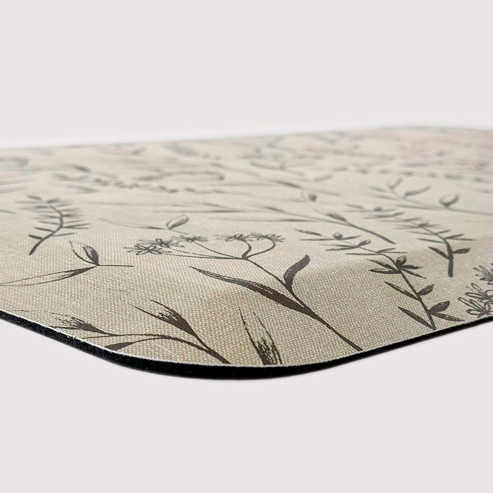 Close up of cushioned anti-fatigue happy feet mat with botanical design.