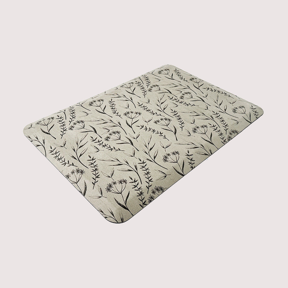 Beautiful botanical designed anti-fatigue mat with black/brown print on beige surface.