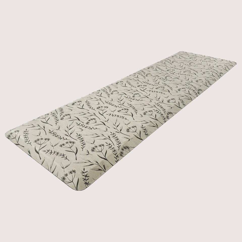 Long anti-fatigue runner perfect for kitchens and bathrooms with botanical black/brown pattern on beige surface. 