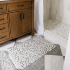 Two Happy Feet Botanical floral mats placed in front of a bathroom sink for standing comfort and floor protection.