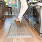 Woman standing on top of a Brisbane Plaid anti-fatigue comfort mat in a kitchen