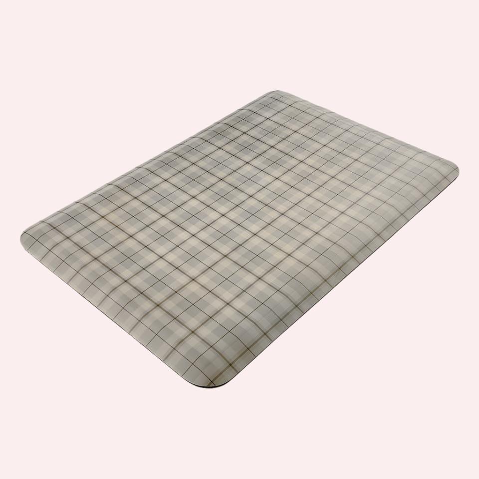 Happy Feet’s tan Brisbane Plaid anti-fatigue small mat at an angle showing for its beveled edges.