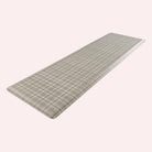 Happy Feet’s tan Brisbane Plaid anti-fatigue runner mat at an angle showing for its beveled edges.