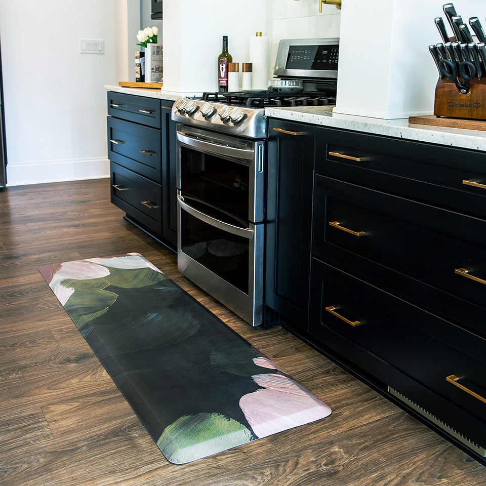 Beautiful anti-fatigue runner in kitchen with an abstract floral design of deep greens, blues, and pinks.