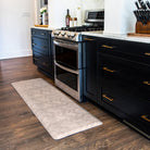 A traditional Herringbone pattern in warm tones featured on a Happy Feet anti-fatigue runner in front of a stove