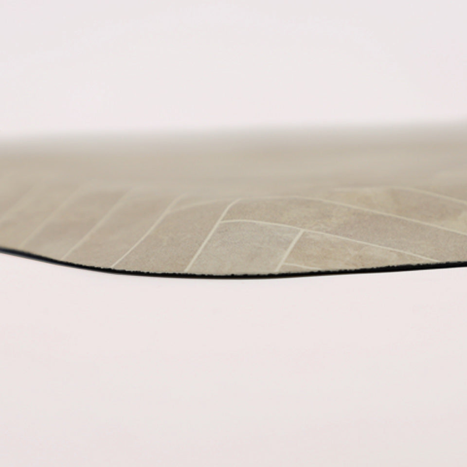 Detailed image of the deluxe anti-fatigue Herringbone mat. The low profile shot displays the 5/8” thick mat, the beveled edging, and the creamy, tile-like surface pattern.