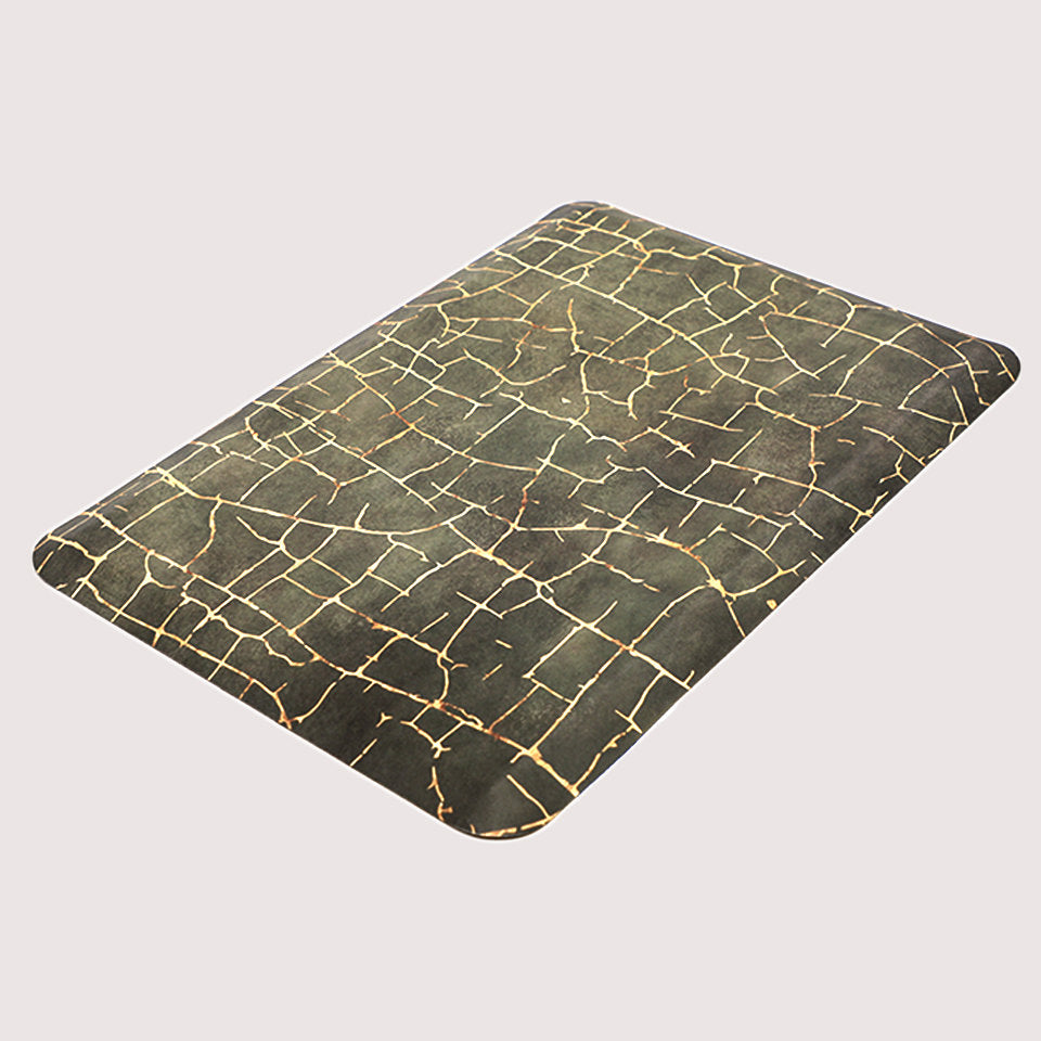 Angled image of anti-fatigue Kintsugi mat, surface of distressed greens and cracks of gold, wipeable and comfortable surface