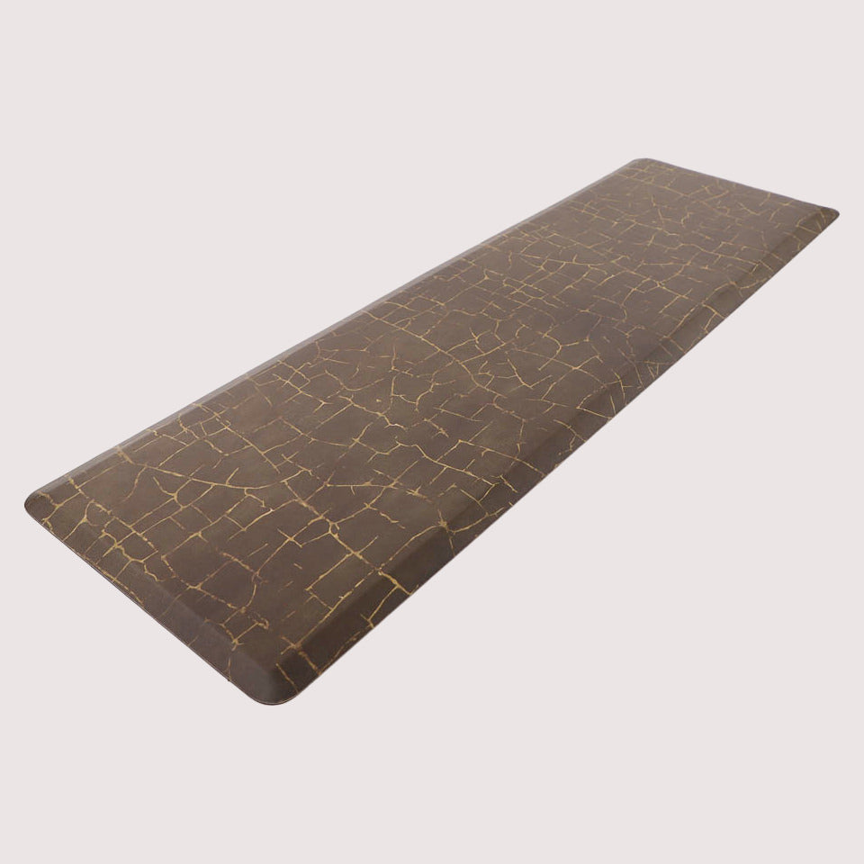 Angled image of anti-fatigue Kintsugi runner mat, surface of distressed browns and cracks of gold, wipeable and comfortable surface