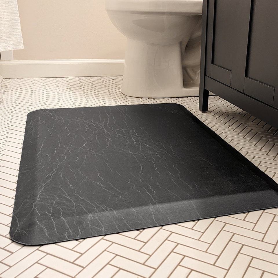 Happy Feet incredibly comfortable anti-fatigue mat in ebony, in use in a restroom in font of a sink for standing comfort